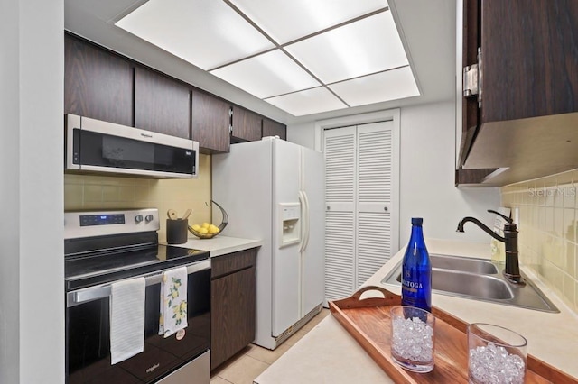 206 Diamond Cv Unit 106, Casselberry, FL 32707 - kitchen with stainless steel appliances, decorative backsplash, a sink, and dark brown cabinets