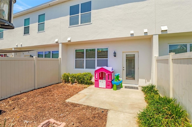 back of property with stucco siding, a patio area, and fence