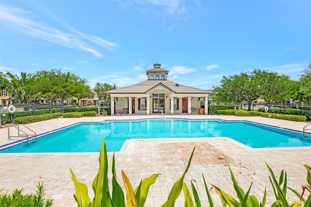 pool with a patio and fence
