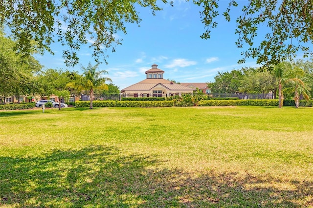 view of home's community with fence and a yard