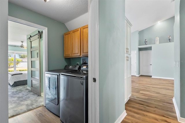 633 Lakehaven Cir, Orlando, FL 32828 - washroom featuring cabinet space, washing machine and clothes dryer, light wood-style flooring, and baseboards