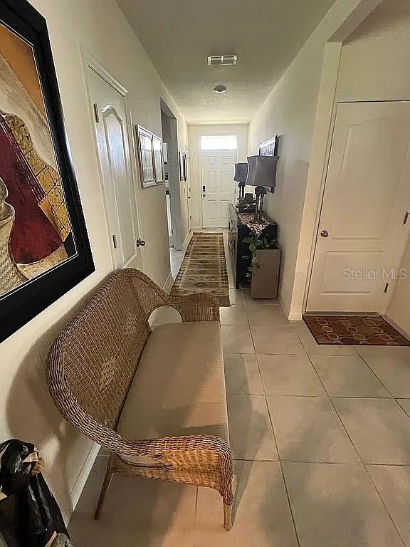 2711 Neverland Dr, New Smyrna Beach, FL 32168 - hall featuring light tile patterned floors and visible vents