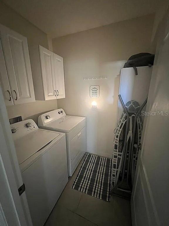 2711 Neverland Dr, New Smyrna Beach, FL 32168 - laundry area with tile patterned flooring, washing machine and dryer, and cabinet space