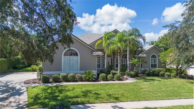 2232 Lake Vilma Dr, Orlando, FL 32835 - view of front of property with driveway, stucco siding, a tiled roof, and a front yard