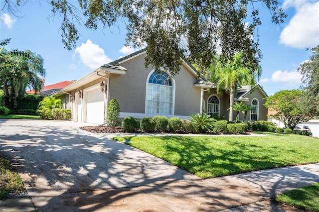 2232 Lake Vilma Dr, Orlando, FL 32835 - view of front of property featuring an attached garage, a front lawn, stucco siding, and driveway