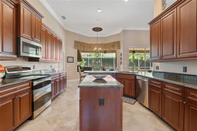 2232 Lake Vilma Dr, Orlando, FL 32835 - kitchen featuring crown molding, a sink, a center island, stainless steel appliances, and pendant lighting