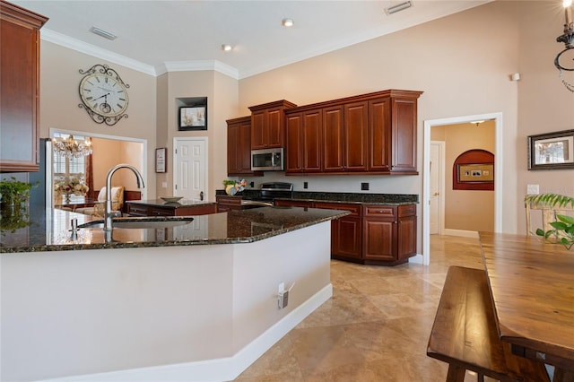 2232 Lake Vilma Dr, Orlando, FL 32835 - kitchen with visible vents, a towering ceiling, appliances with stainless steel finishes, a sink, and a notable chandelier