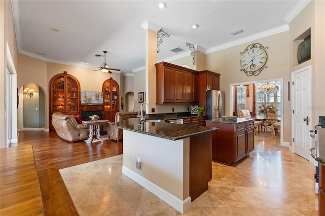 2232 Lake Vilma Dr, Orlando, FL 32835 - kitchen featuring crown molding, a sink, arched walkways, stainless steel appliances, and a kitchen island