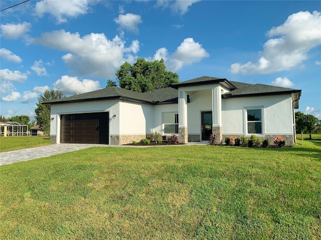 prairie-style home featuring stucco siding, an attached garage, a front yard, and stone siding