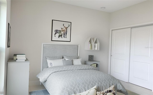 bedroom with tile patterned flooring and a closet