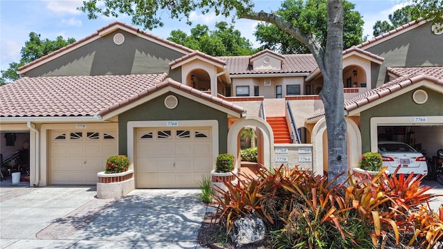 mediterranean / spanish house with driveway, a tile roof, and stucco siding