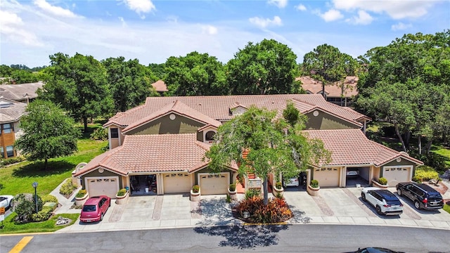 view of front of house with stucco siding, a tiled roof, and driveway