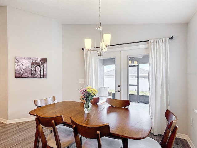 2005 Noble Dr, Davenport, FL 33837 - dining space with french doors, wood finished floors, a chandelier, and baseboards
