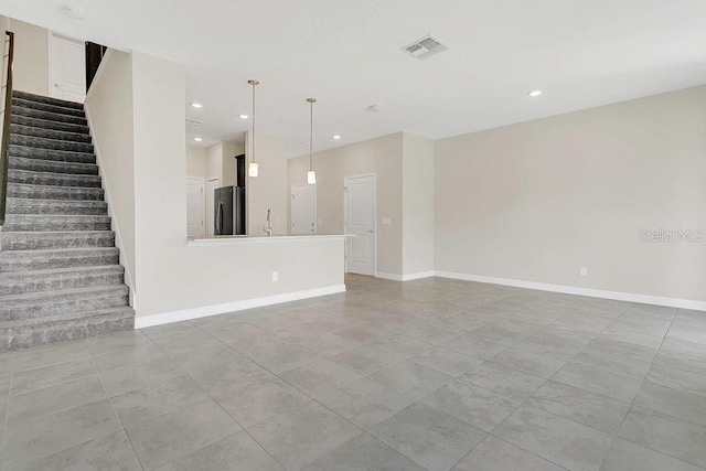unfurnished living room featuring stairs, recessed lighting, baseboards, and visible vents