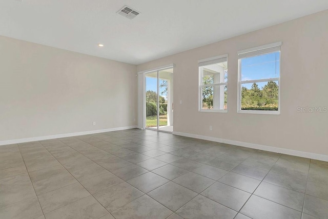 empty room featuring recessed lighting, baseboards, visible vents, and tile patterned flooring