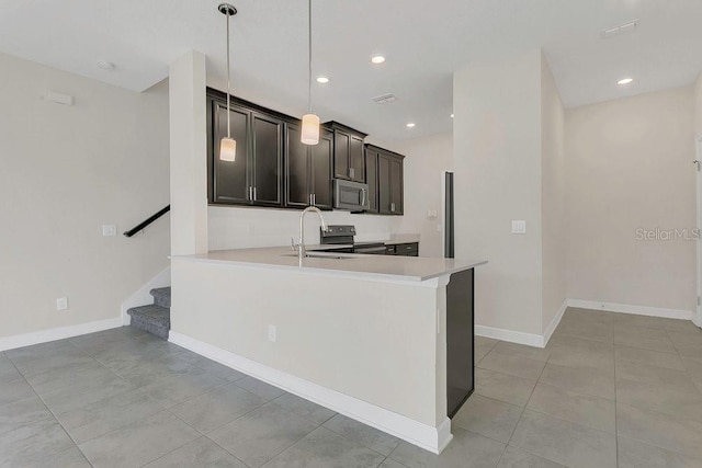 kitchen featuring light tile patterned flooring, a sink, light countertops, stainless steel appliances, and baseboards