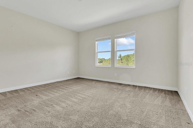 carpeted spare room with baseboards