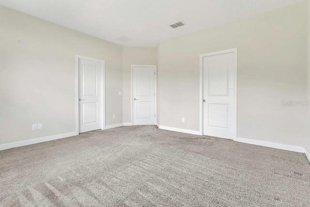 carpeted spare room with baseboards and visible vents