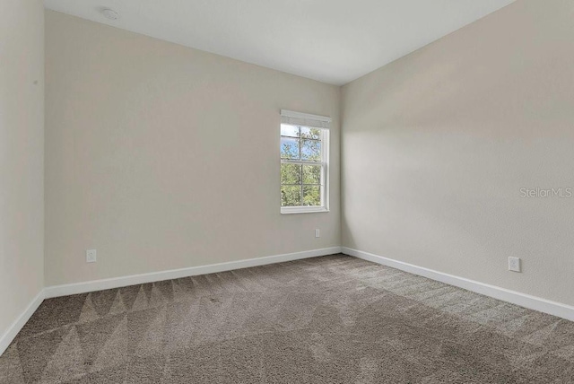 carpeted spare room with baseboards