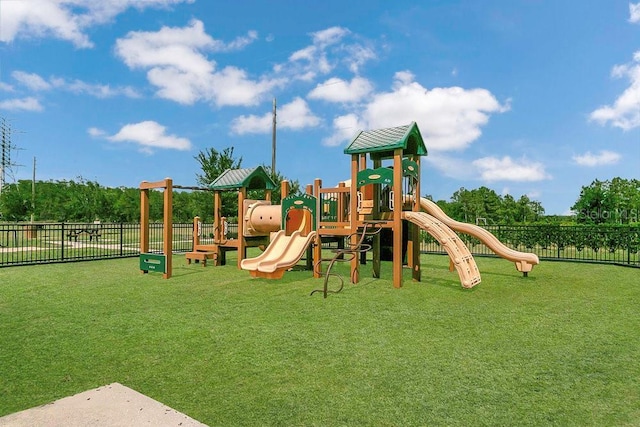 community jungle gym featuring fence and a lawn