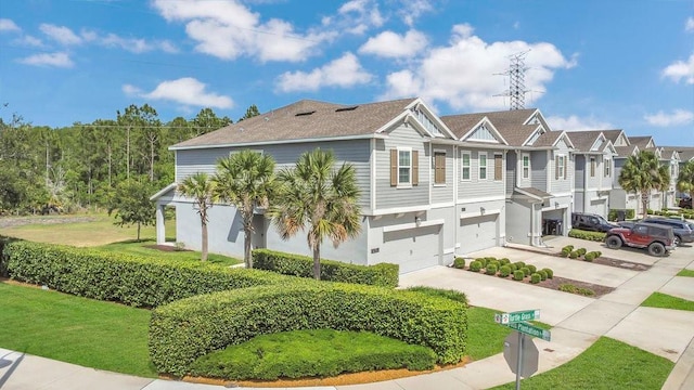 view of front facade featuring driveway, a residential view, a front yard, and a garage