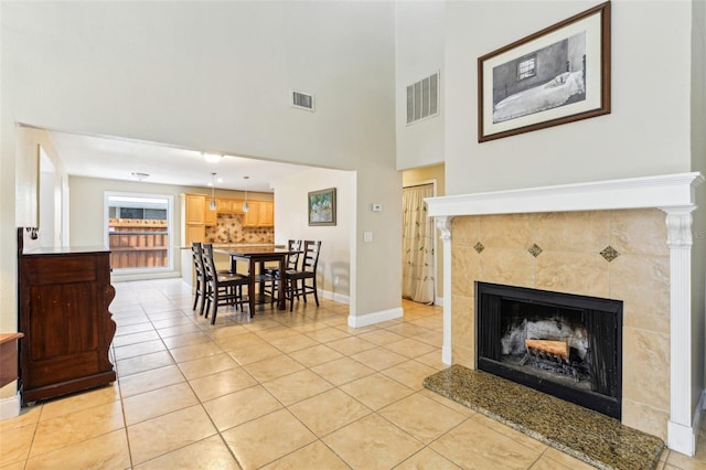 2260 Winslow Cir, Casselberry, FL 32707 - interior space with visible vents, a towering ceiling, light tile patterned flooring, a fireplace, and baseboards