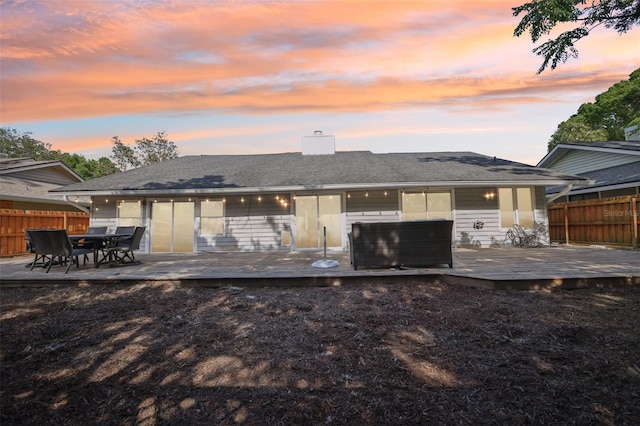 2260 Winslow Cir, Casselberry, FL 32707 - back of house at dusk with a chimney, fence, and a deck