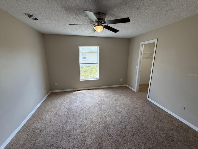 unfurnished room featuring carpet floors, ceiling fan, baseboards, and visible vents