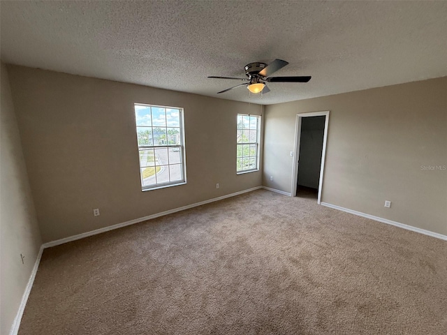 unfurnished bedroom with carpet floors, a textured ceiling, baseboards, and ceiling fan