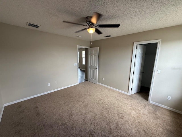 unfurnished bedroom featuring carpet flooring, baseboards, a spacious closet, and visible vents