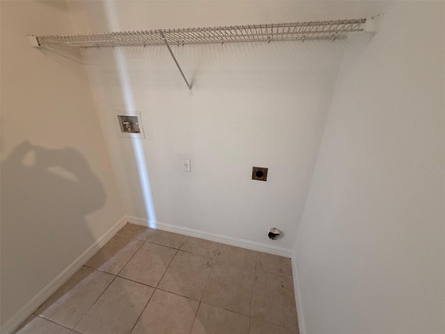 washroom with washer hookup, laundry area, electric dryer hookup, light tile patterned floors, and baseboards