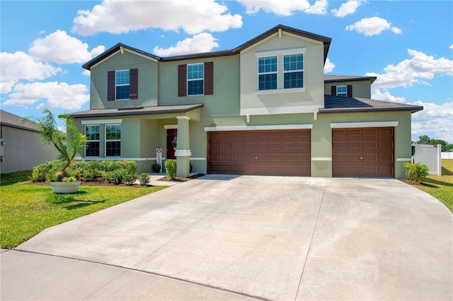 view of front facade featuring an attached garage, a front lawn, stucco siding, and concrete driveway