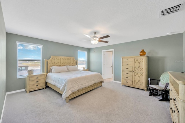 bedroom featuring light colored carpet, baseboards, visible vents, and ceiling fan