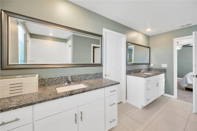 ensuite bathroom featuring a sink, tile patterned floors, a ceiling fan, and visible vents