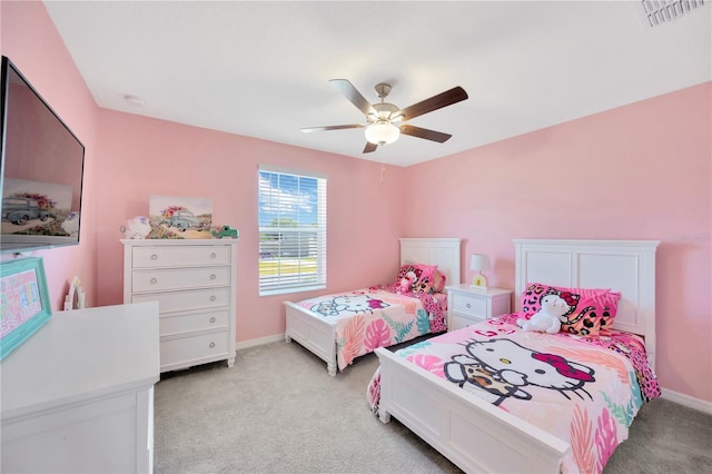 bedroom with baseboards, light carpet, a ceiling fan, and visible vents