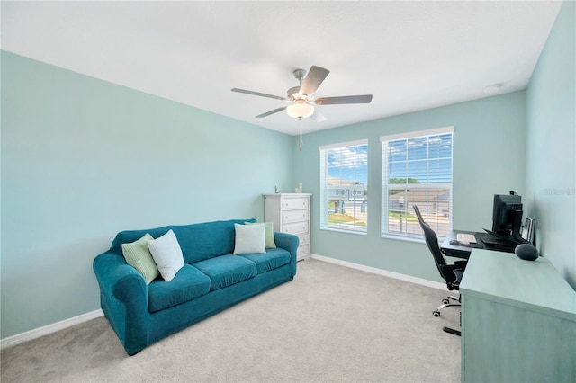 home office featuring baseboards, ceiling fan, and light carpet