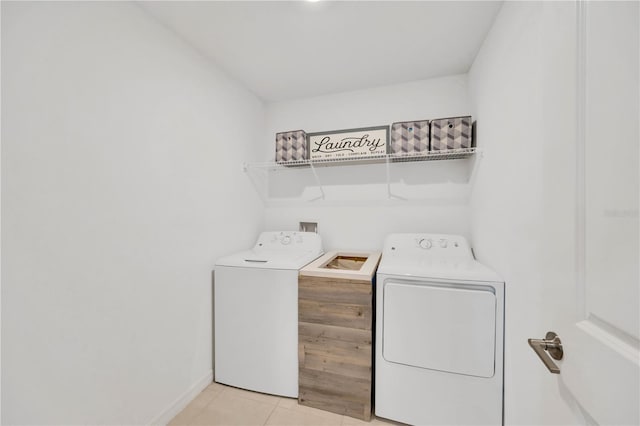 laundry area featuring light tile patterned floors, baseboards, laundry area, and washing machine and dryer