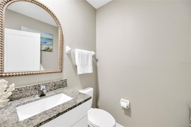 half bathroom with toilet and vanity