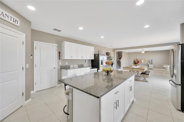 kitchen with visible vents, freestanding refrigerator, a center island, stainless steel fridge with ice dispenser, and light tile patterned floors