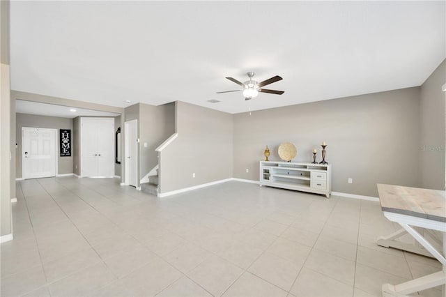 unfurnished living room with baseboards, a ceiling fan, stairs, and light tile patterned flooring