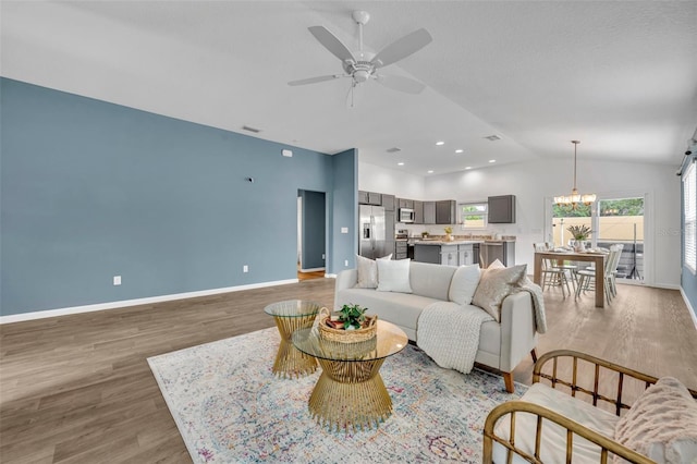 1397 Gatlin Pl, The Villages, FL 32163 - living area featuring baseboards, light wood finished floors, ceiling fan with notable chandelier, and lofted ceiling