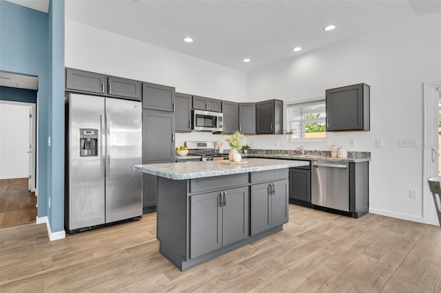 1397 Gatlin Pl, The Villages, FL 32163 - kitchen with baseboards, a kitchen island, stainless steel appliances, and light wood-style flooring