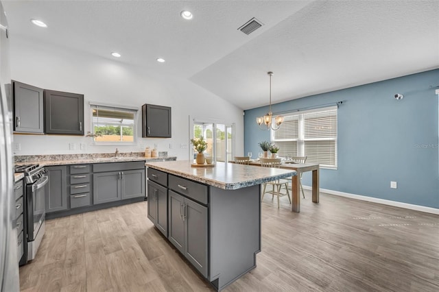 1397 Gatlin Pl, The Villages, FL 32163 - kitchen with visible vents, a chandelier, stainless steel range with gas stovetop, vaulted ceiling, and gray cabinetry