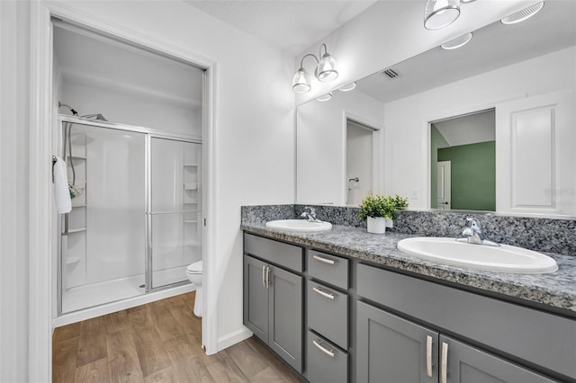 1397 Gatlin Pl, The Villages, FL 32163 - full bathroom featuring wood finished floors, a sink, a stall shower, and toilet