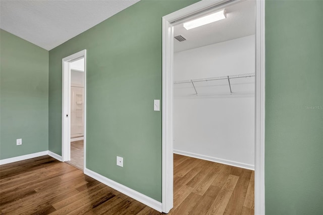 1397 Gatlin Pl, The Villages, FL 32163 - unfurnished bedroom with baseboards, wood finished floors, vaulted ceiling, visible vents, and a closet