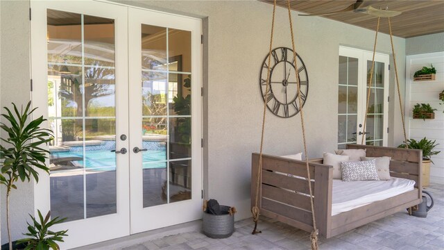doorway to property featuring ceiling fan, a patio area, stucco siding, and french doors
