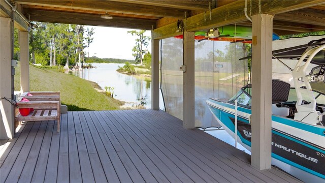 dock area with a water view and a yard