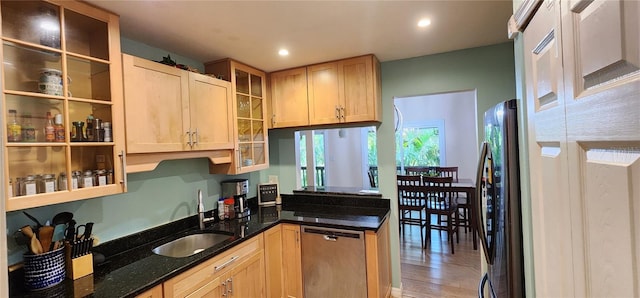 kitchen with appliances with stainless steel finishes, a sink, dark stone countertops, recessed lighting, and glass insert cabinets