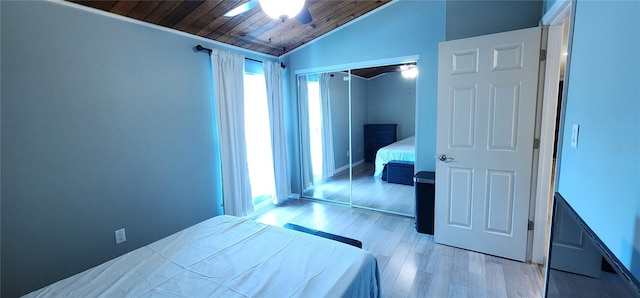 unfurnished bedroom featuring light wood-style floors, wood ceiling, lofted ceiling, and a closet