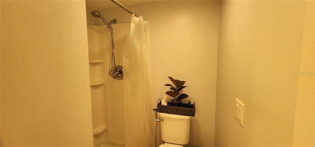 full bath featuring toilet and a shower with curtain